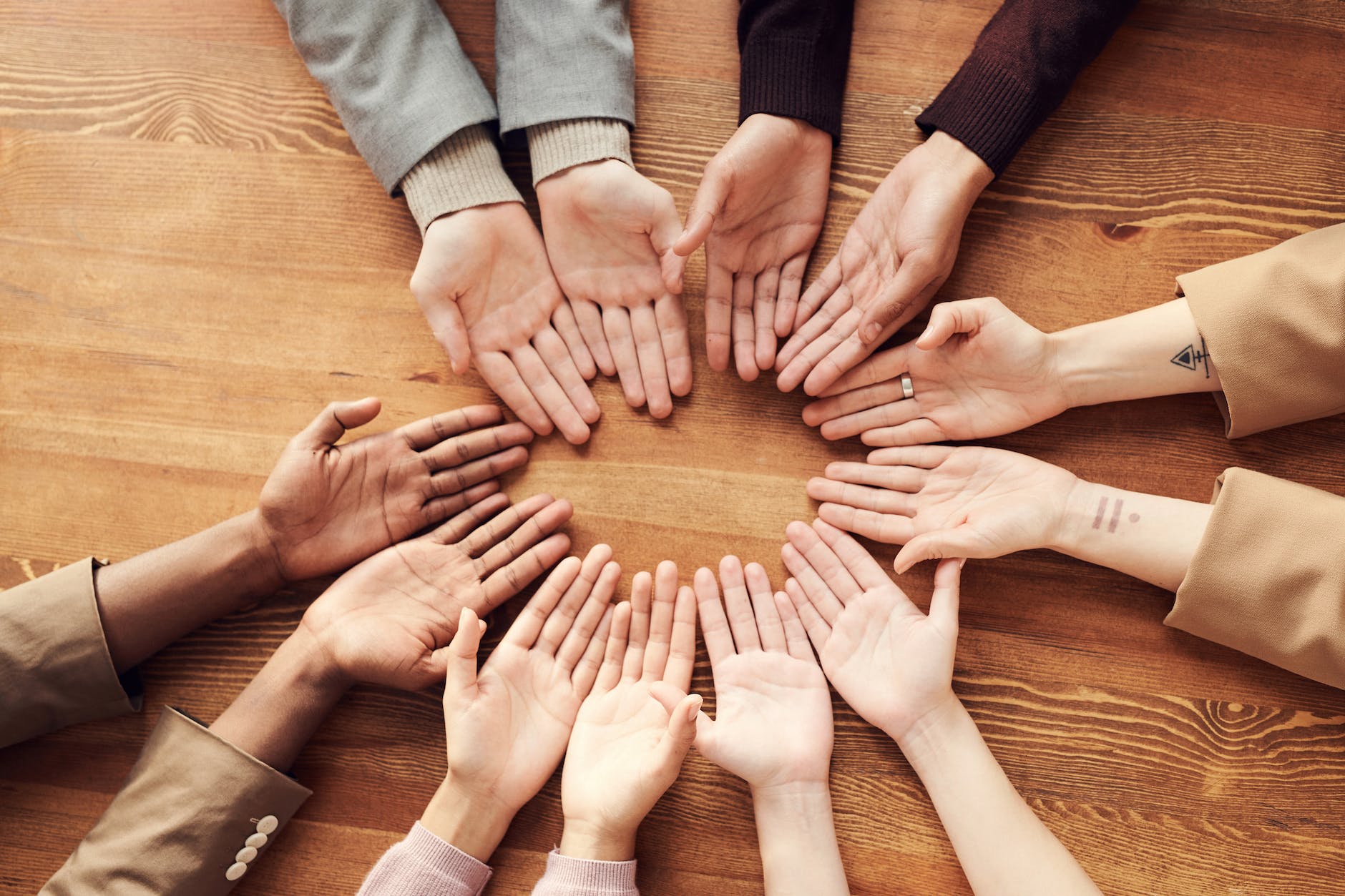 photo of people s hand on top of wooden table